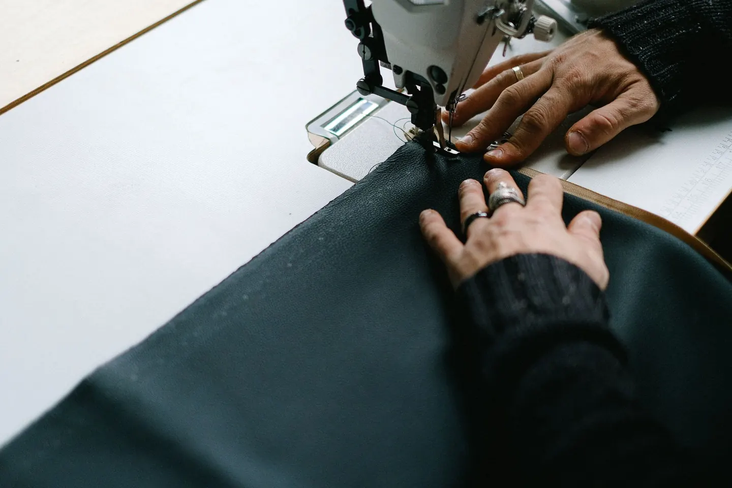 Mains guidant un tissu sous une machine à coudre