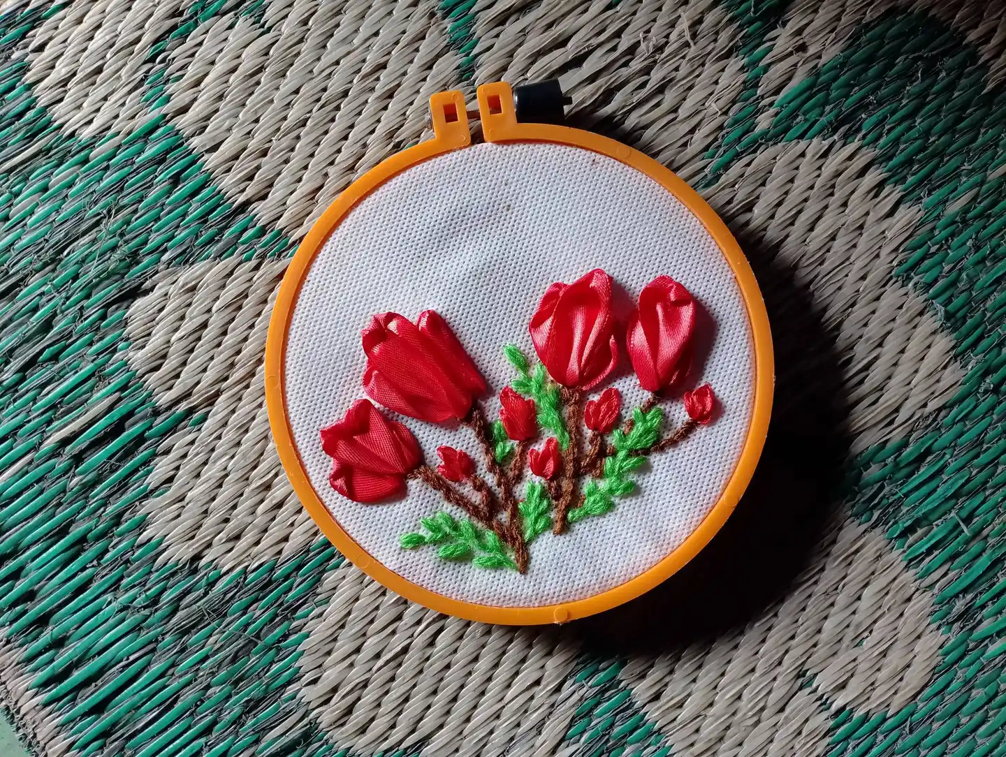 Broderie florale dans un tambour posé sur un textile tissé