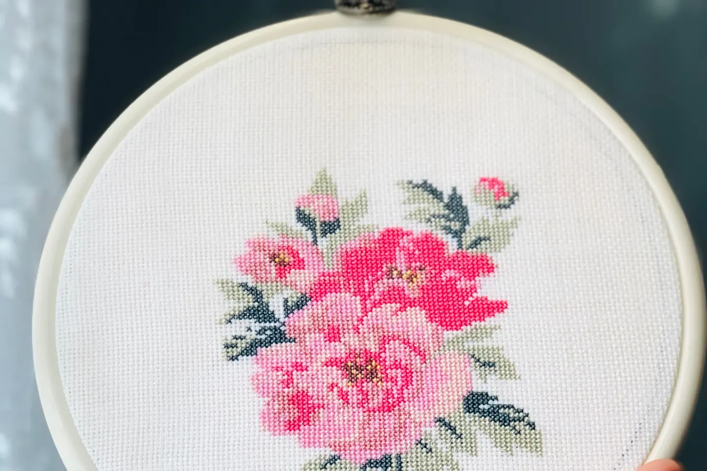 Tambour tenu à la main avec une broderie florale au point de croix