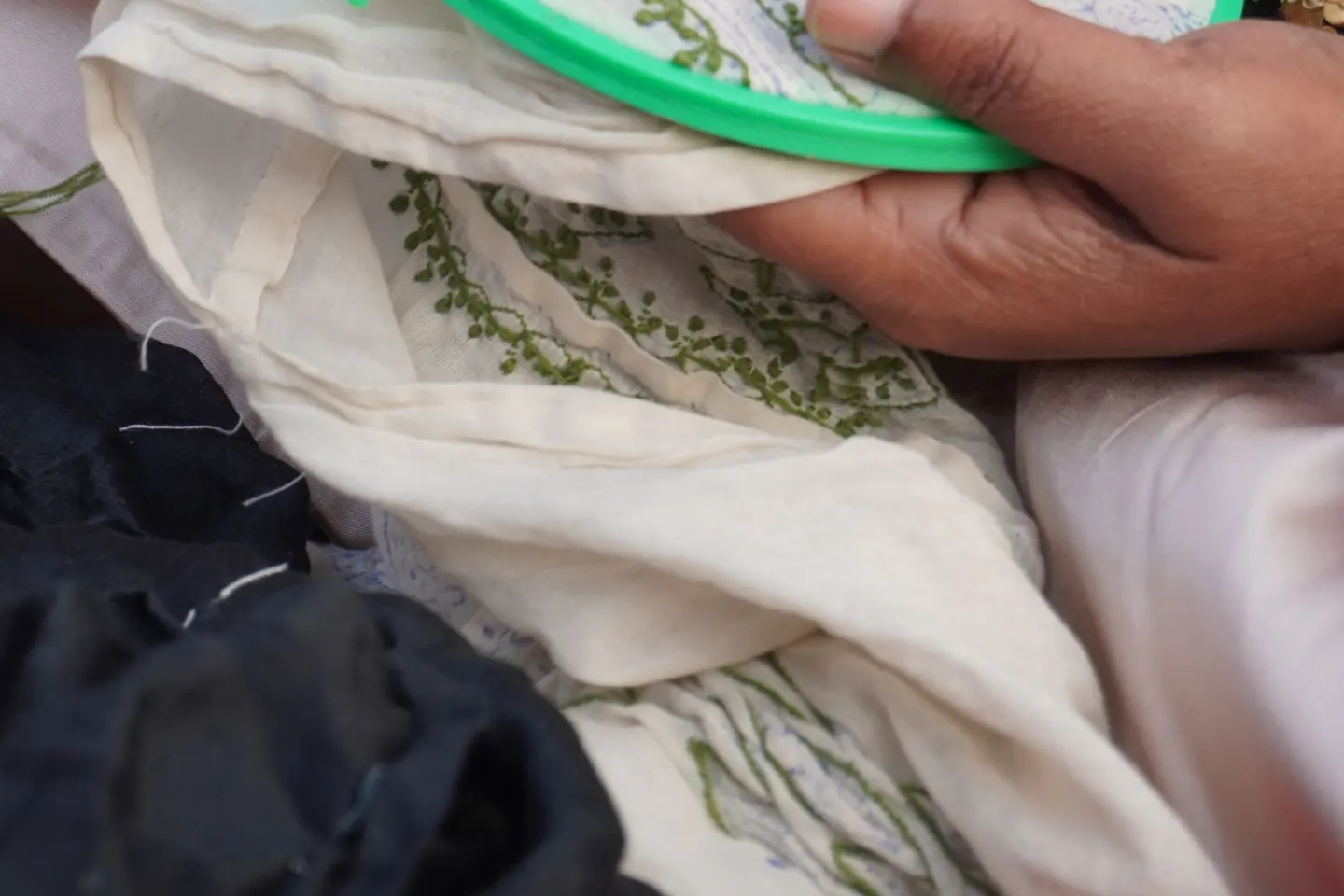 Gros plan sur des mains brodant un textile