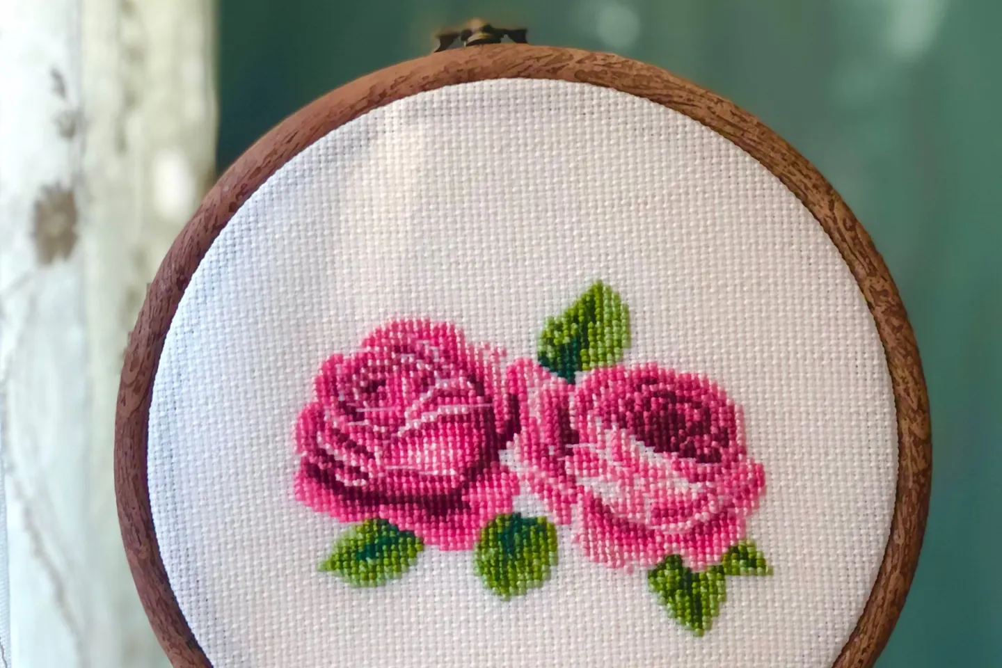 Tambour tenu à la main avec un motif floral au point de croix