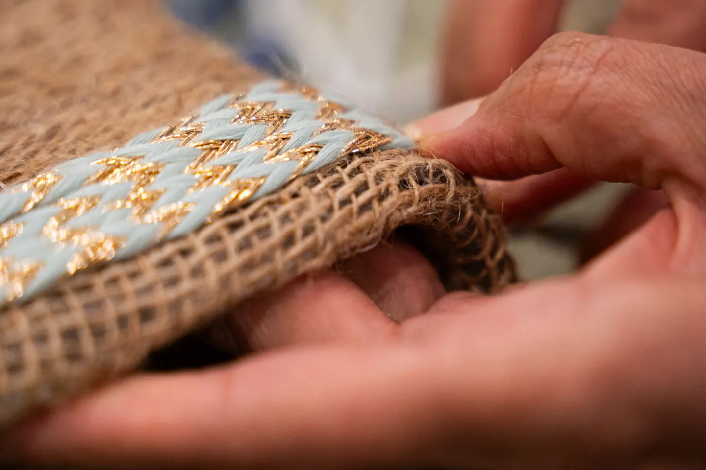 Mains travaillant un textile fait main